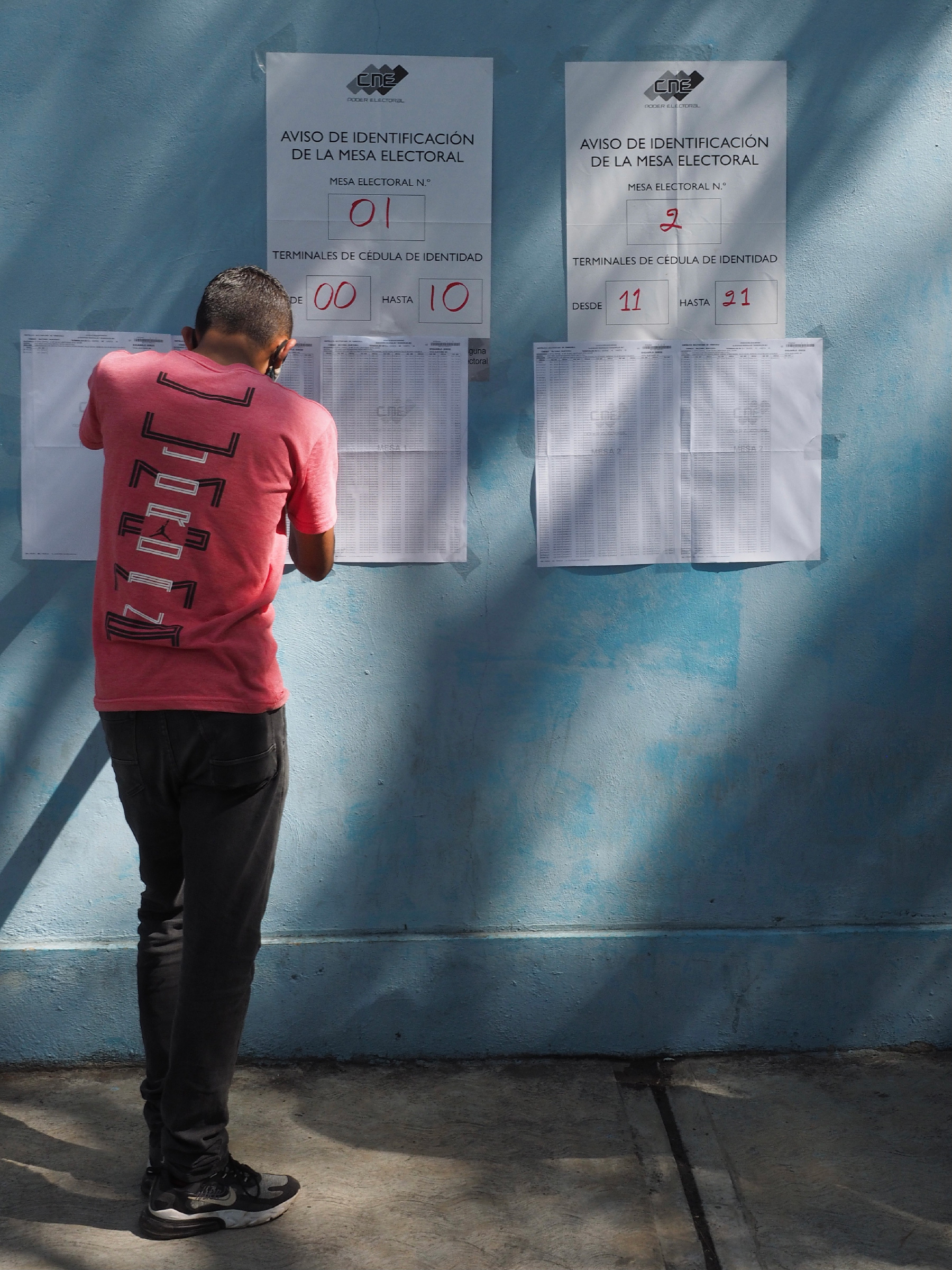 A Venezuelan voter searches for his name on the voter list at the Liceo Pedro Emilio Coll in the Coche Parish in Caracas, Venezuela during elections on November 21, 2021.