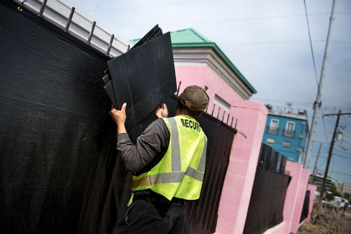 A security guard removes boards used for privacy from a fence outside the Jackson Women's Health Organization, the last abortion clinic in Mississippi, after patients left for the day on April 5, 2018, in Jackson, Mississippi.