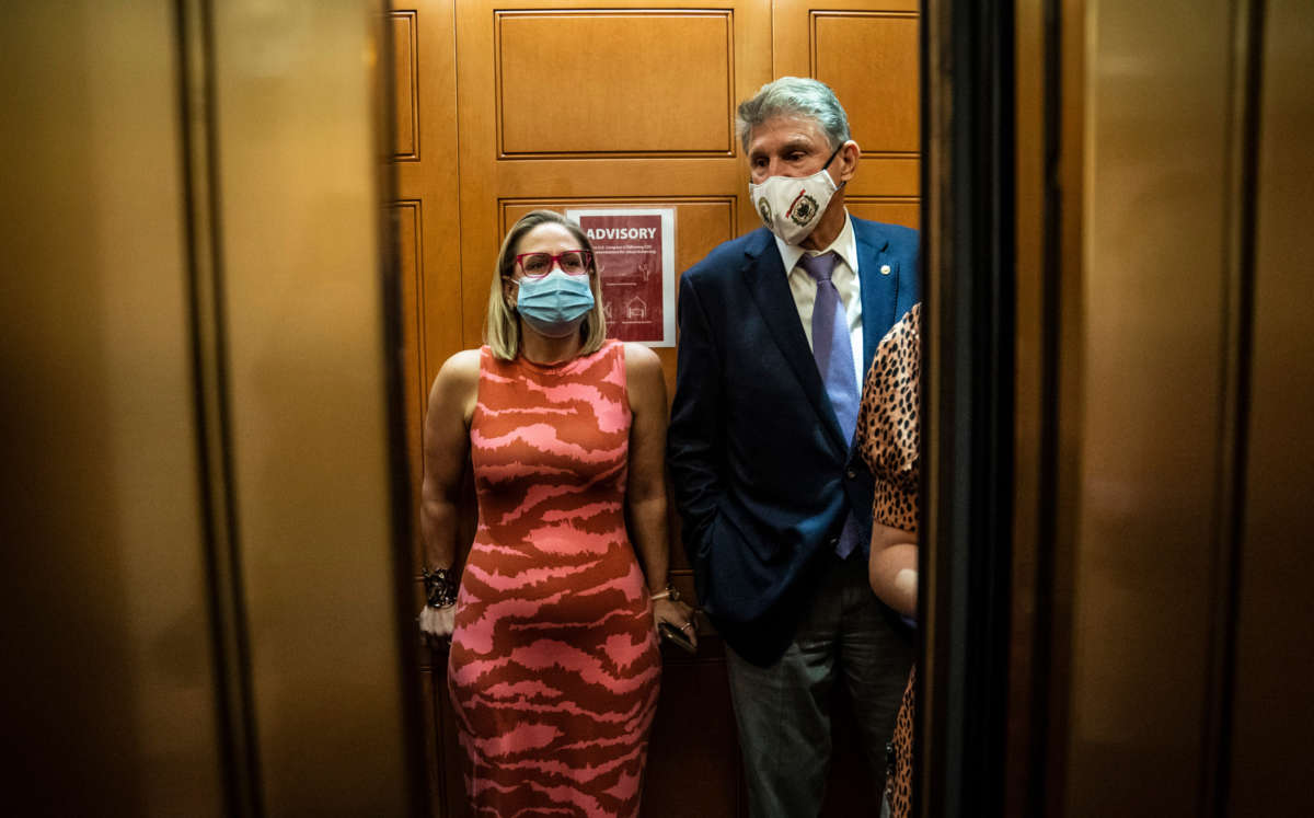 Senators Kyrsten Sinema and Joe Manchin board an elevator after a private meeting between the two of them on Capitol Hill on September 30, 2021, in Washington, D.C.