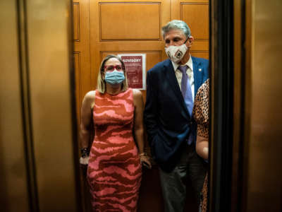 Senators Kyrsten Sinema and Joe Manchin board an elevator after a private meeting between the two of them on Capitol Hill on September 30, 2021, in Washington, D.C.
