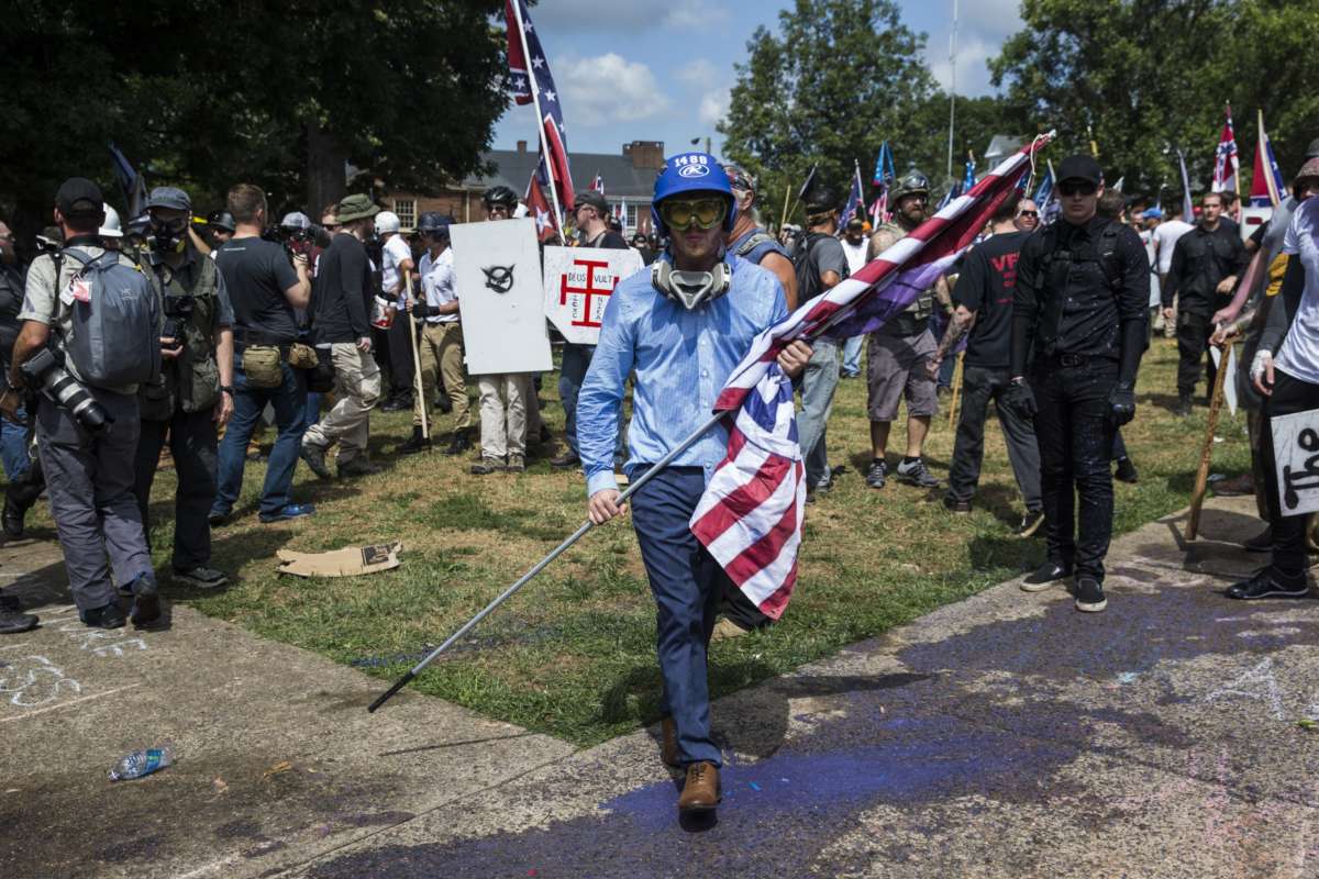 A white supremacist carries a white nationalist flag during clashes with counter protestors at Emancipation Park where the white nationalists are protesting the removal of the Robert E. Lee monument in Charlottesville, Virginia, on August 12, 2017.