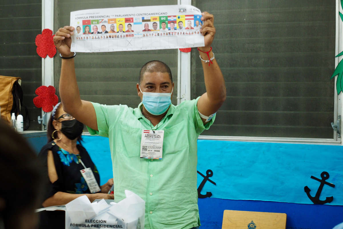 An election worker holds up a presidential ballot marking a preference for the LIBRE party as part of the vote counting process at the end of election day, Tegucigalpa