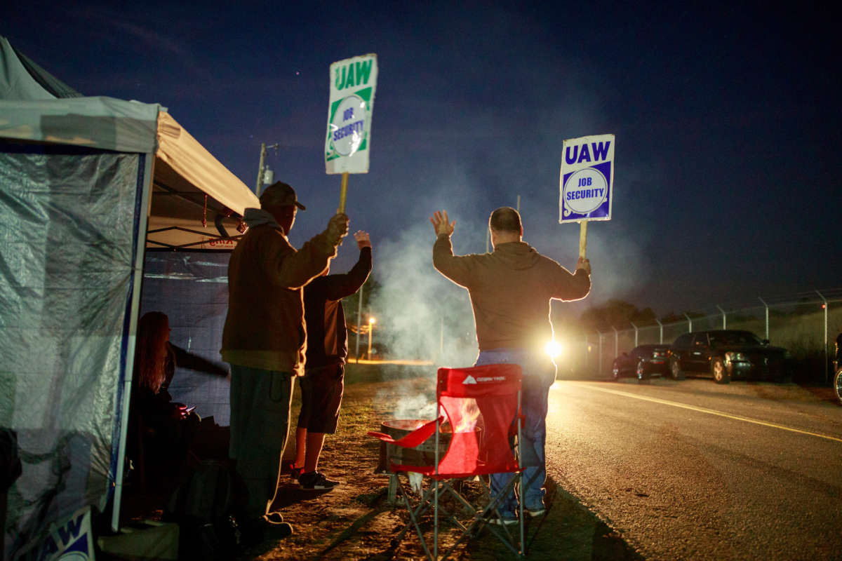 Workers wave to a passing motorist as United Auto Workers (UAW) members strike outside the Bedford Casting Operations plant in Bedford, Indiana, on October 18, 2019.
