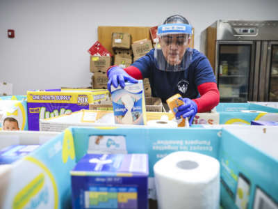 Chelsea Collaborative volunteer Jessica Armijo sorts through aid to be distributed, including food, diapers and baby formula in Chelsea, Massachusetts, on May 2, 2020.