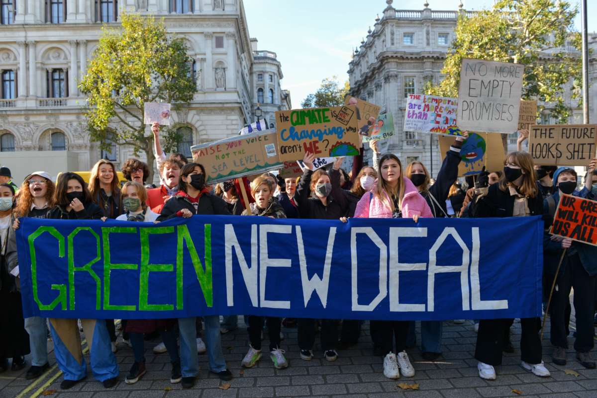 Demonstrators hold a banner during the protest which reads 'green new deal'