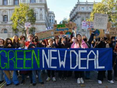 Demonstrators hold a banner during the protest which reads 'green new deal'