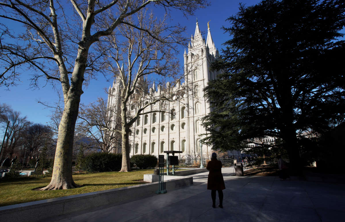 A woman takes a picture of The Church of Jesus Christ of Latter-Day Saints on December 17, 2019, in Salt Lake City, Utah.