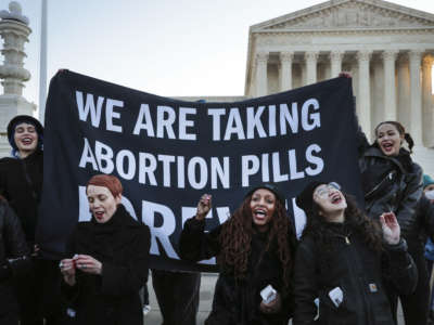 A bunch of people take abortion pills on the steps of the United States Supreme Court