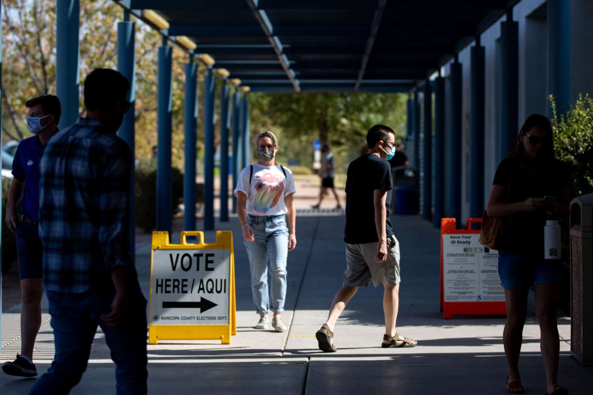 People walk around the entrance of a polling place