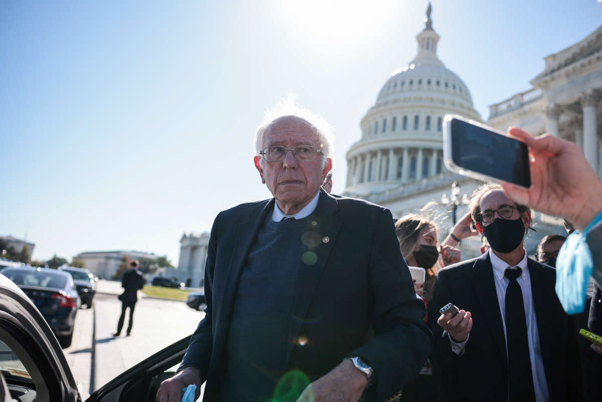Sen. Bernie Sanders looks at reporters while stepping into a car