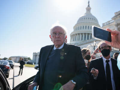 Sen. Bernie Sanders looks at reporters while stepping into a car