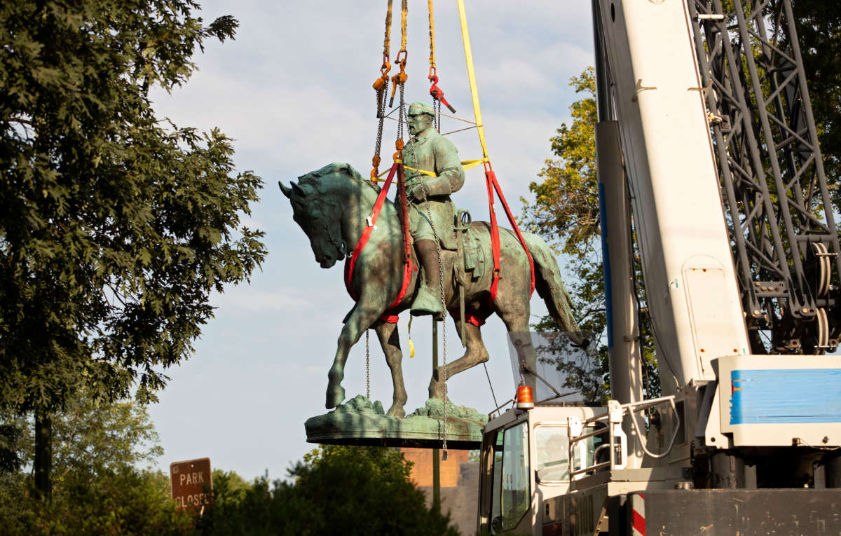 Workers remove the statue of Confederate General Robert E. Lee from a park in Charlottesville, Virginia, on July 10, 2021.