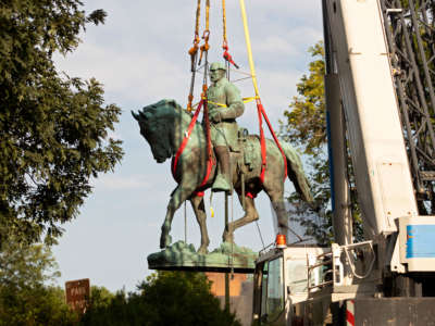 Workers remove the statue of Confederate General Robert E. Lee from a park in Charlottesville, Virginia, on July 10, 2021.