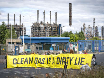 Climate activists demonstrate outside the gates of the Mossmorran petrochemical refinery near Cowdenbeath, Scotland, to protest against flaring and pollution at the plant on August 1, 2021.