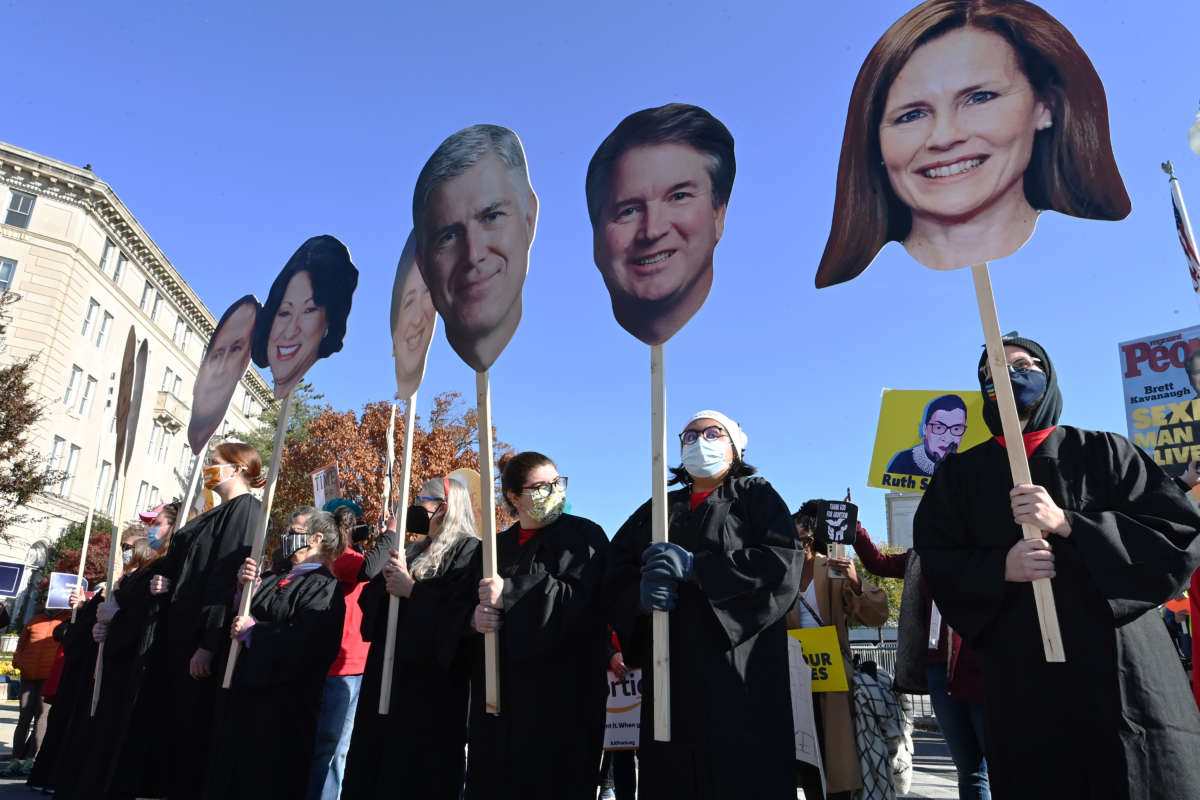 Protesters display cardboard cutouts of the faces of the United States Supreme Court justices