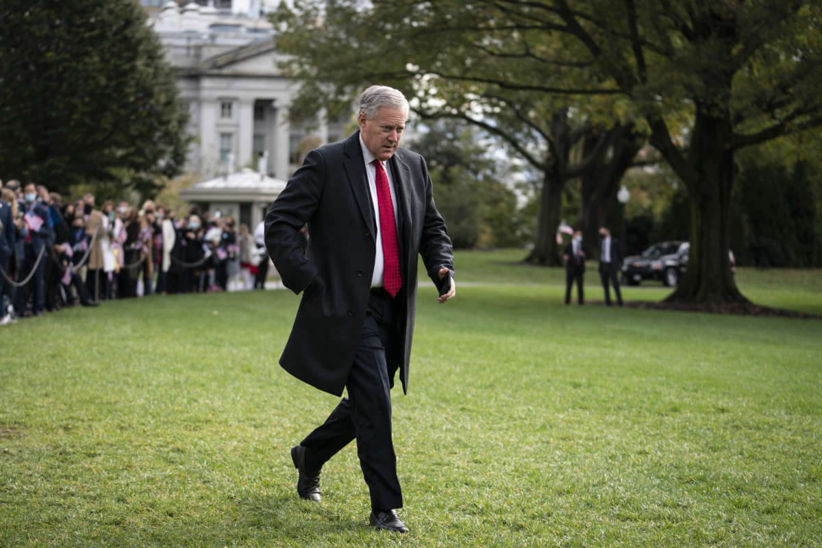 Mark Meadows walks across a field