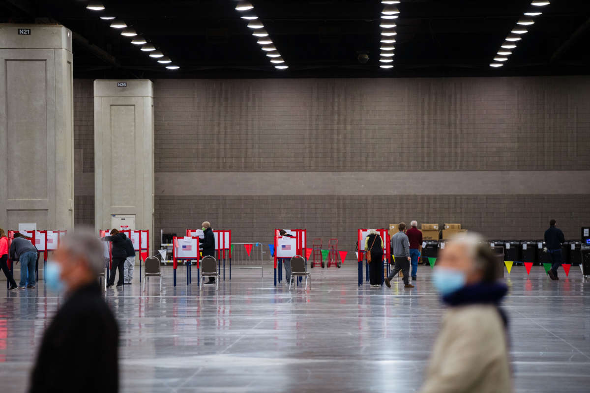 Voters can be seen at booths as people waiting in line in the foreground