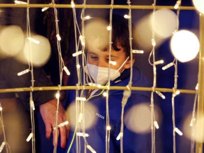 A boy with a face mask looks the Christmas lights during the winter in Granada, Spain, amid the coronavirus pandemic on December 20, 2021.