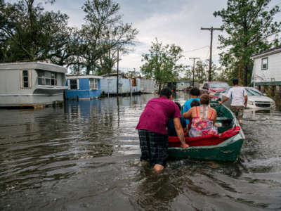 The Maldonado family travel by boat to their home after it was flooded during Hurricane Ida on August 31, 2021, in Barataria, Louisiana.