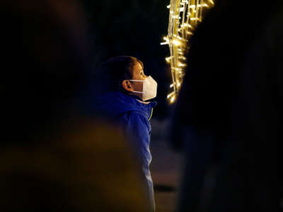 A boy with a face mask looks the Christmas lights during the winter in Granada, Spain, amid the coronavirus pandemic on December 20, 2021.