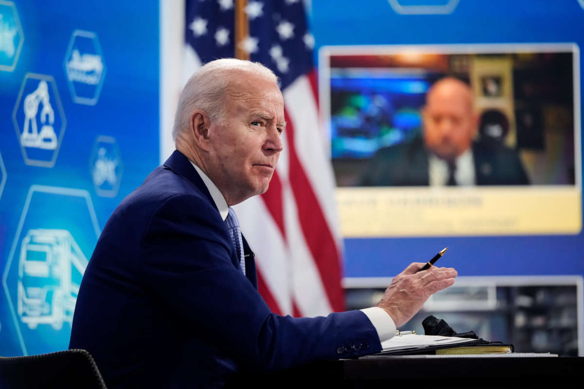 President Joe Biden sits at a desk