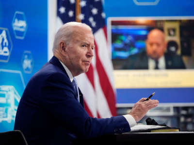 President Joe Biden sits at a desk