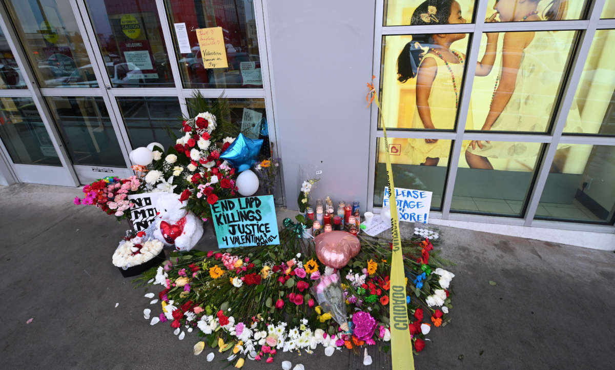 Flowers and balloons are left along with a sign reading "Release the Footage Moore" at a makeshift memorial for the teenage girl who was killed by a police stray bullet at a Burlington Coat Factory in North Hollywood, California, December 27, 2021.
