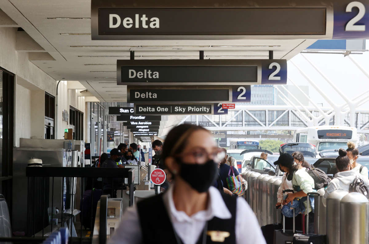 People gather outside the Delta Air Lines departures level at Los Angeles International Airport (LAX) on August 25, 2021, in Los Angeles, California.