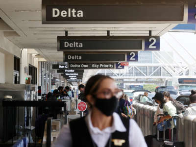 People gather outside the Delta Air Lines departures level at Los Angeles International Airport (LAX) on August 25, 2021, in Los Angeles, California.