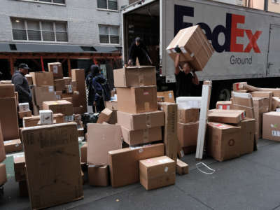Dozens of packages are lined up along a Manhattan street as a FedEx truck makes deliveries on December 6, 2021, in New York City.