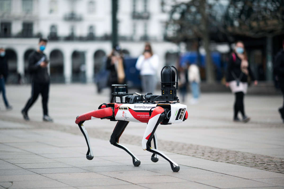 A Boston Dynamics robot walks across cobblestone