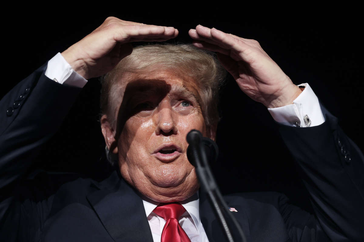 Donald Trump shields his eyes from lights while on stage