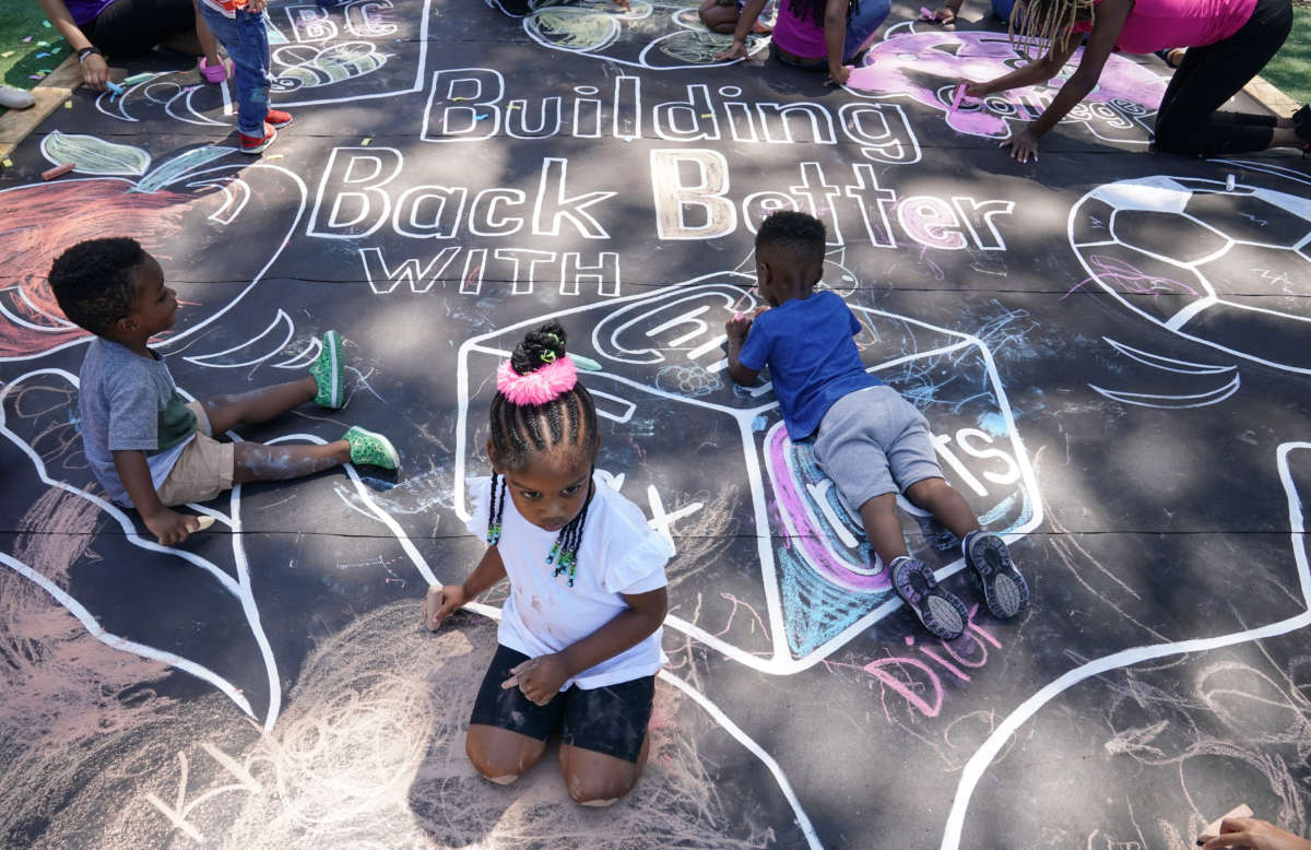 Children and teachers from the KU Kids Deanwood Childcare Center complete a mural in celebration of the launch of the Child Tax Credit on July 14, 2021, at the KU Kids Deanwood Childcare Center in Washington, D.C.