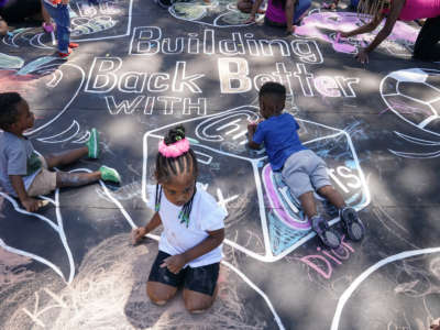Children and teachers from the KU Kids Deanwood Childcare Center complete a mural in celebration of the launch of the Child Tax Credit on July 14, 2021, at the KU Kids Deanwood Childcare Center in Washington, D.C.