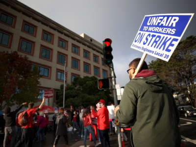 A union worker holds a strike sign as he pickets with nurses outside of the Kaiser Permanente San Francisco Medical Center on November 10, 2021, in San Francisco, California.