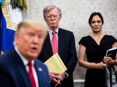 National Security Advisor John Bolton and White House Press Secretary Stephanie Grisham listen as President Donald Trump participates in a meeting in the Oval Office at the White House on July 9, 2019, in Washington, D.C.
