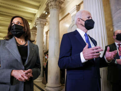 Vice President Kamala Harris listens to President Joe Biden speak to reporters as he departs through the Hall of Columns on Capitol Hill on January 6, 2022, in Washington, D.C.