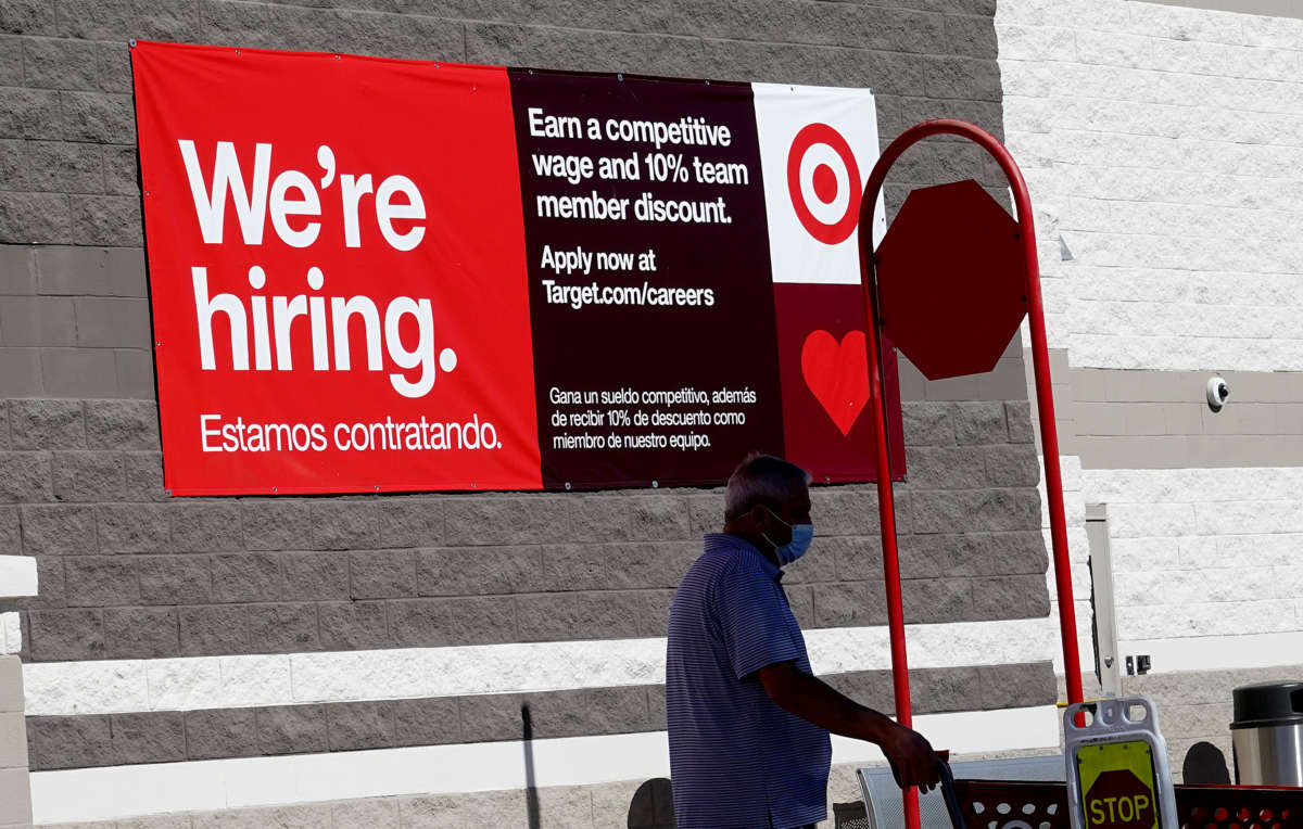 A We're Hiring sign hangs on the wall of a Target store on December 3, 2021, in Miami, Florida.