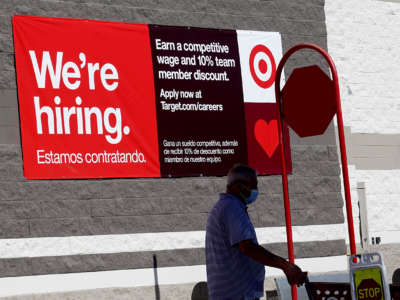 A We're Hiring sign hangs on the wall of a Target store on December 3, 2021, in Miami, Florida.
