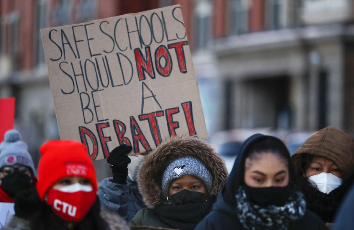 Members of the Chicago Teachers Union listen to speakers at a press conference outside of John Spry Community School in Chicago's Little Village neighborhood on January 10, 2022.