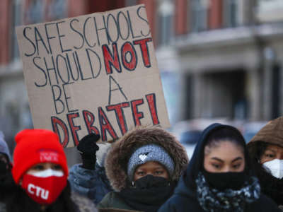 Members of the Chicago Teachers Union listen to speakers at a press conference outside of John Spry Community School in Chicago's Little Village neighborhood on January 10, 2022.