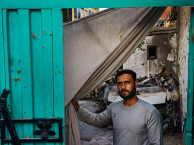 A man stands in the ruins of what was once his home