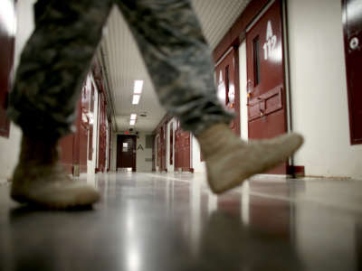 An officer walks through a prison cell block in Camp V where prisoners are housed in the single cell facility at the U.S. military prison for so-called enemy combatants on June 25, 2013, in Guantánamo Bay, Cuba.