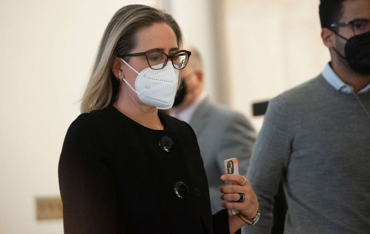 Sen. Kyrsten Sinema arrives for a meeting between President Joe Biden and the Senate Democratic Caucus to discuss the passing of legislation to protect the constitutional right to vote and the integrity of elections, on Capitol Hill in Washington, D.C., January 13, 2022.