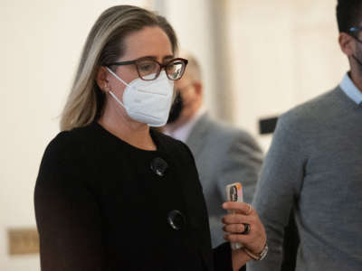 Sen. Kyrsten Sinema arrives for a meeting between President Joe Biden and the Senate Democratic Caucus to discuss the passing of legislation to protect the constitutional right to vote and the integrity of elections, on Capitol Hill in Washington, D.C., January 13, 2022.