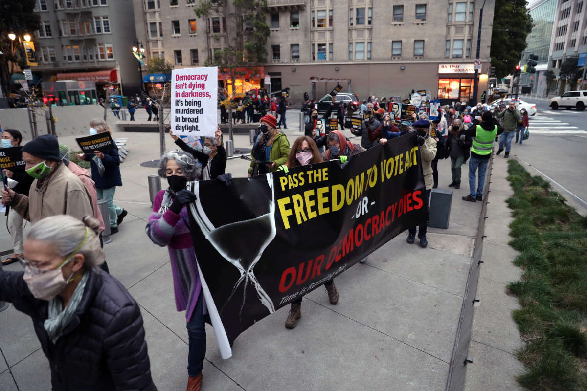 On the one year anniversary of the attack on the U.S. Capitol, people march past the Department of Justice as Indivisible SF and Indivisible East Bay hold a vigil and march in San Francisco, California, on January 6, 2022.