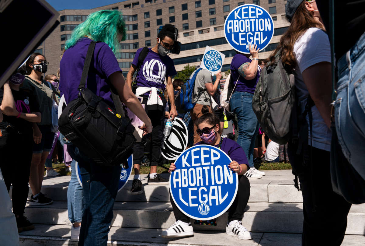 Women rights activists hold up signs as they gather at Freedom Plaza for a pre-march rally of the annual Women's March on October 2, 2021, in Washington, D.C.