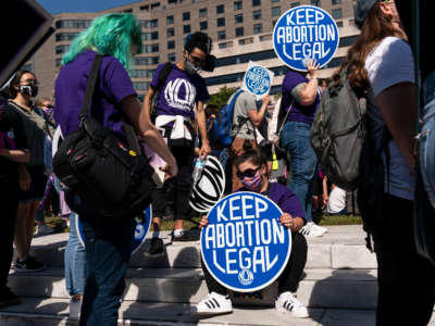 Women rights activists hold up signs as they gather at Freedom Plaza for a pre-march rally of the annual Women's March on October 2, 2021, in Washington, D.C.