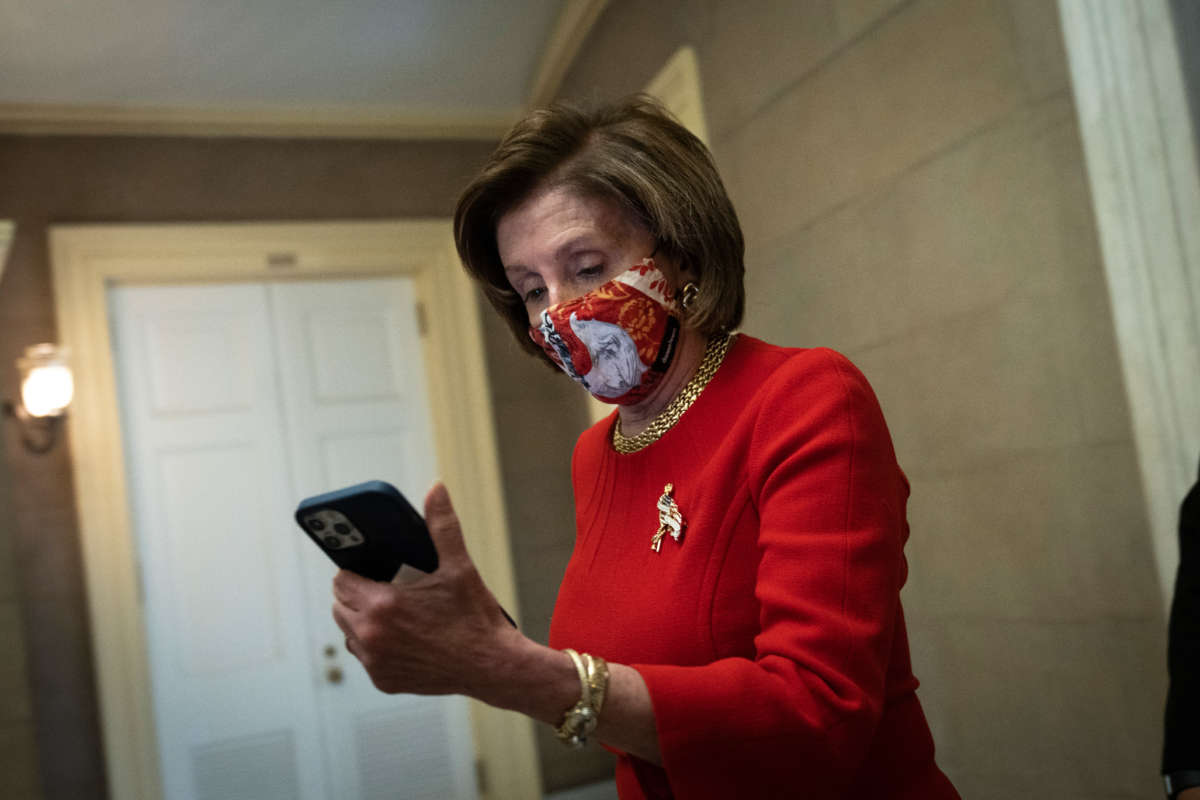 Speaker of the House Nancy Pelosi looks at her phone as she returns to her office after meeting with the family of George Floyd at the U.S. Capitol on May 25, 2021, in Washington, D.C.