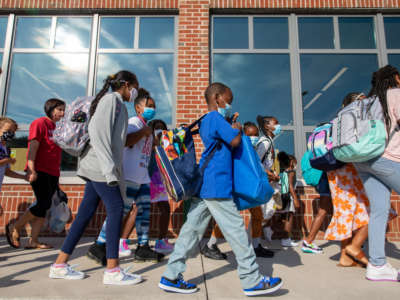 Students prepare to enter the building of Stratford Landing Elementary School in Alexandria, Virginia, on August 23, 2021.